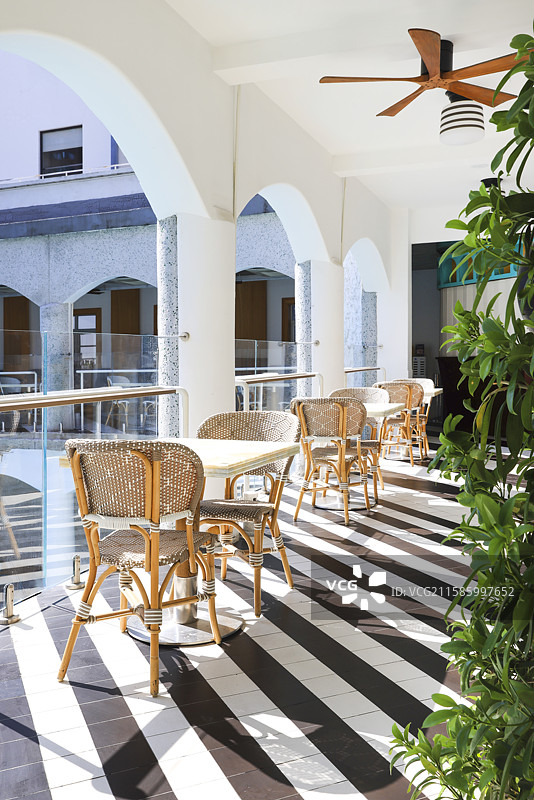 城市度假泳池边的休闲时光以及藤椅桌子图片素材