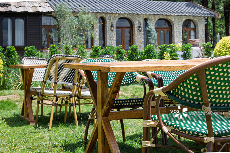 庭院中的木质桌椅与绿植环绕的休闲空间图片素材