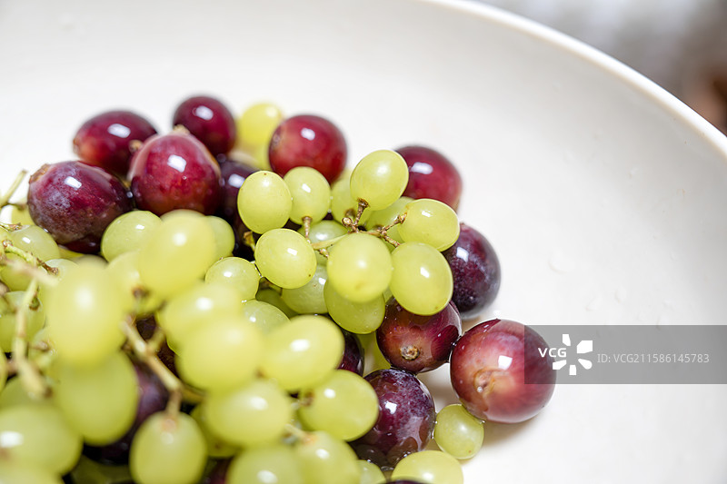白色盘子中的多色葡萄，多角度特写图片素材