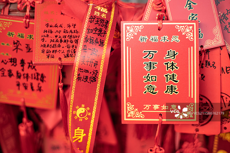 中国道教宗教象征传统文化拍摄主题  ,铁栏杆子上悬挂着大量万事如意身体健康许愿牌子，户外白昼无人图像图片素材