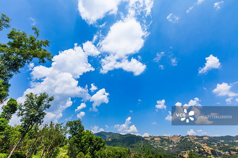 蓝天白云下的绿色山丘图片素材