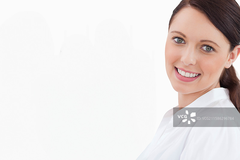 穿着白色衬衫的青少年女性在摄影棚肖像中微笑着看向镜头，留有空白空间图片素材