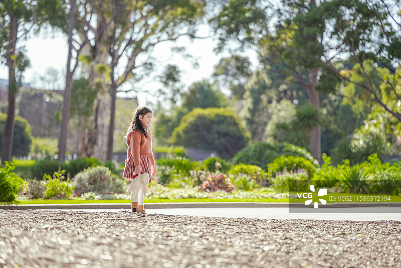 花园小道上的漂亮可爱小女孩图片素材