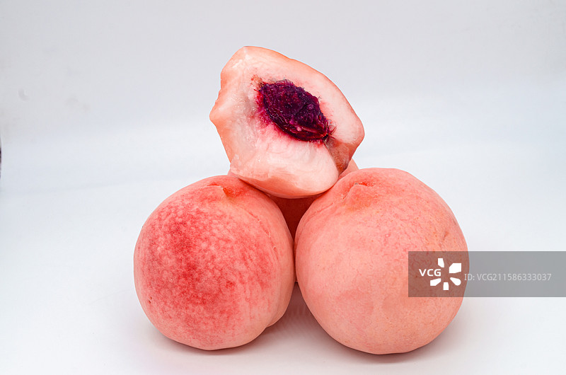 中国水果饮食产业影棚拍摄主题，几个粉红色的肥城桃子水蜜桃毛桃垒在一起露出横截面桃核，室内无人图像摄影图片素材