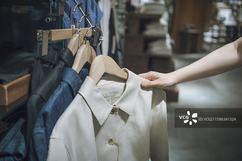 店内手持白色衬衫的场景图片素材
