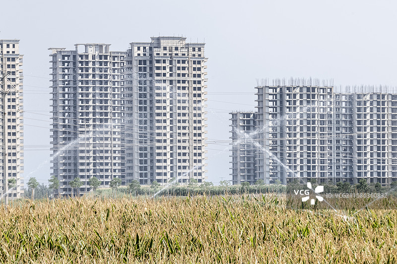 农田风景和建设中的现代城市建筑结构图片素材