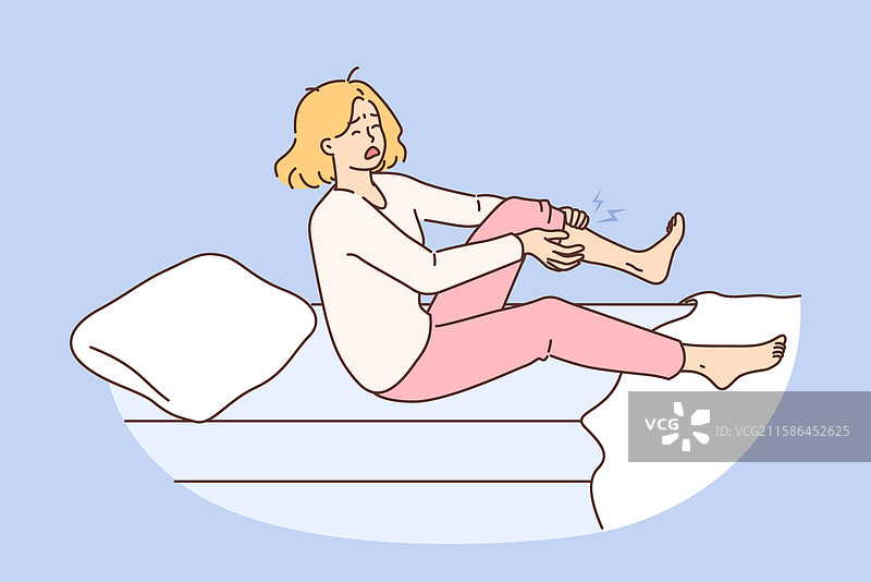夜间抽筋让女人惊醒，紧握着腿部。图片素材