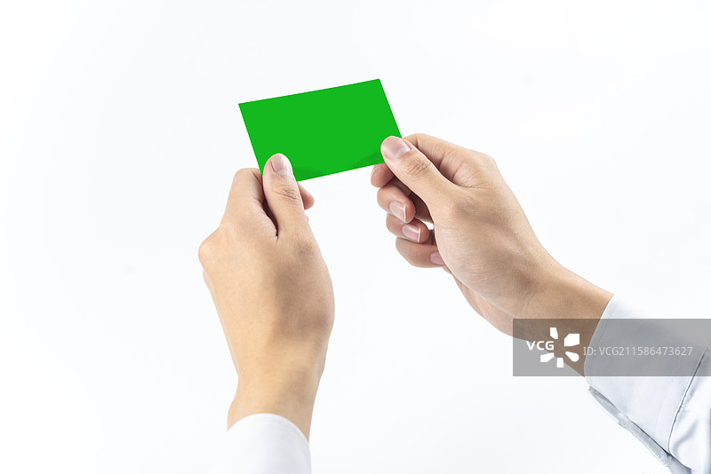 白色背景下双手拿空白银行卡的特写镜头图片素材