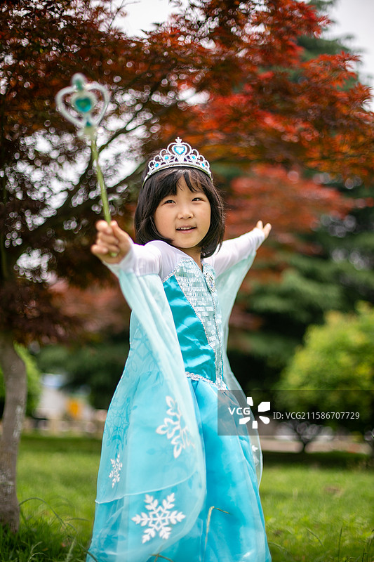 穿着公主裙的女孩站在公园里图片素材