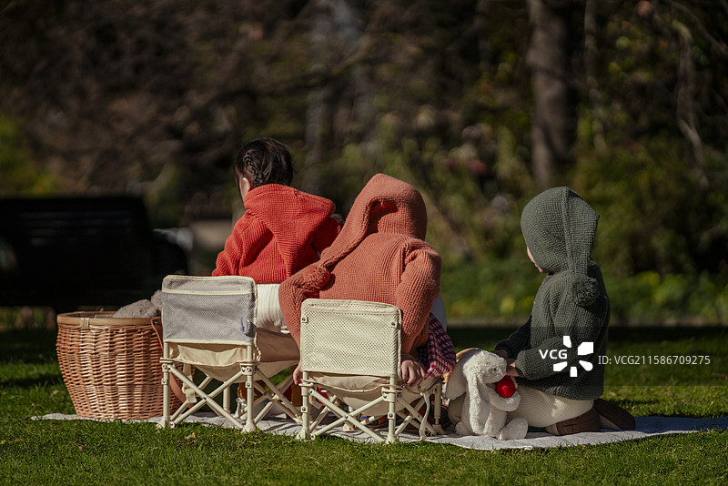 博物馆前花园草坪上野餐的三个小孩图片素材