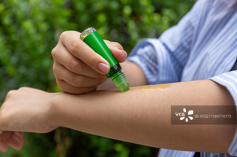 户外在身上涂抹防蚊液图片素材