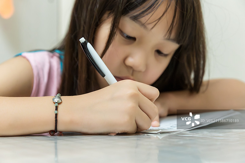 小女孩专注伏案书写瞬间图片素材