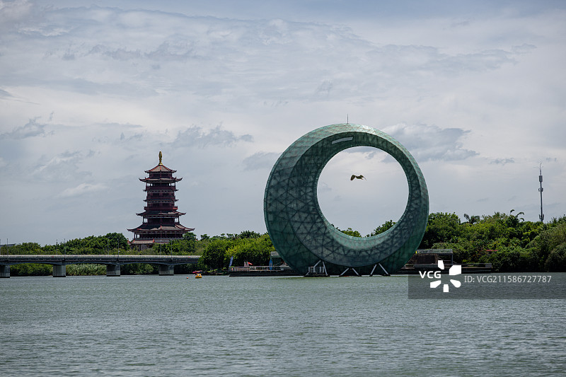 福建厦门杏林湾湖畔的现代艺术环与传统塔楼图片素材