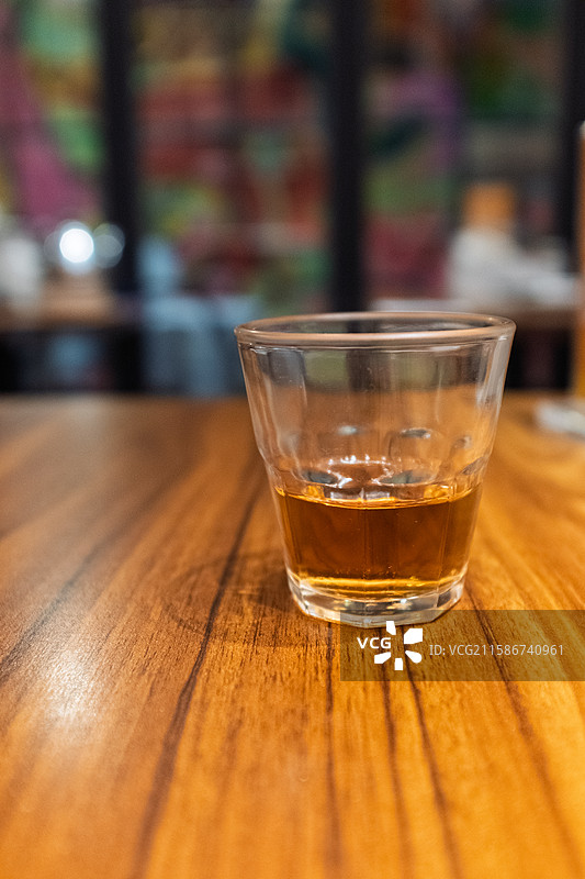 木质桌面上的一杯琥珀色饮料图片素材