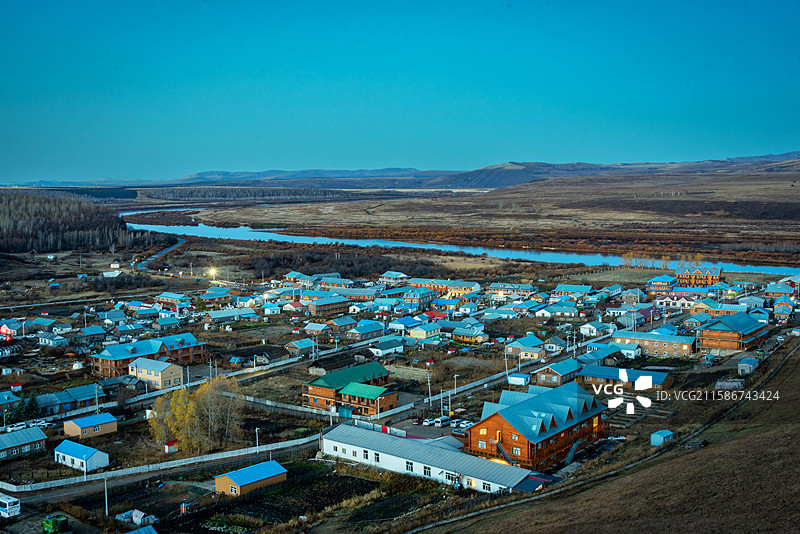 室韦临江屯中俄界河额尔古纳河河畔小镇全景，蓝顶木制房，山丘河流相映，宁静美丽。图片素材