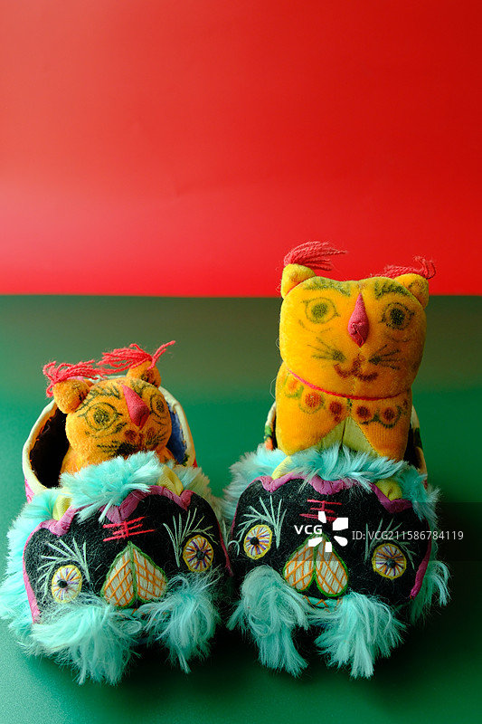 绿色红色背景下老手工老虎头鞋。布老虎。留白设计素材背景图。辟邪保平安图片素材