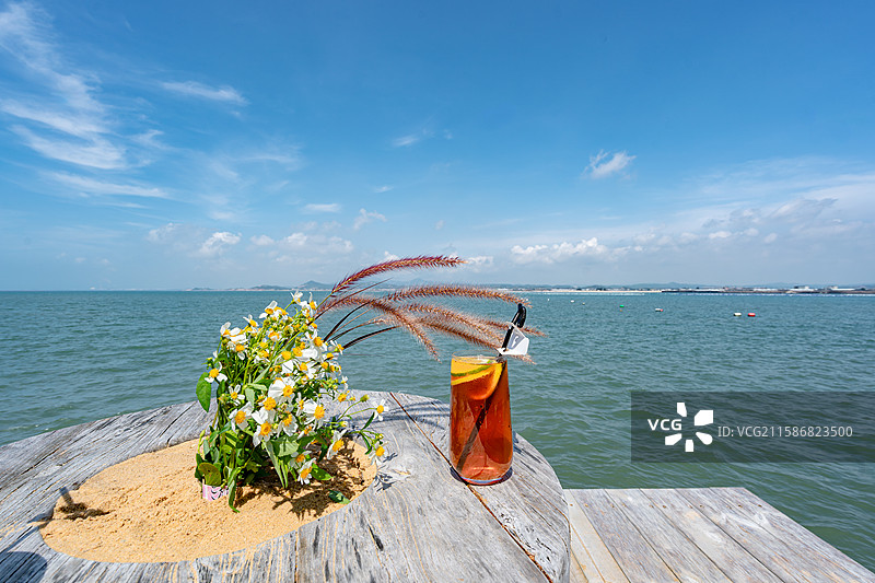 盛夏海边木桌上的小野花野草与柠檬饮料图片素材