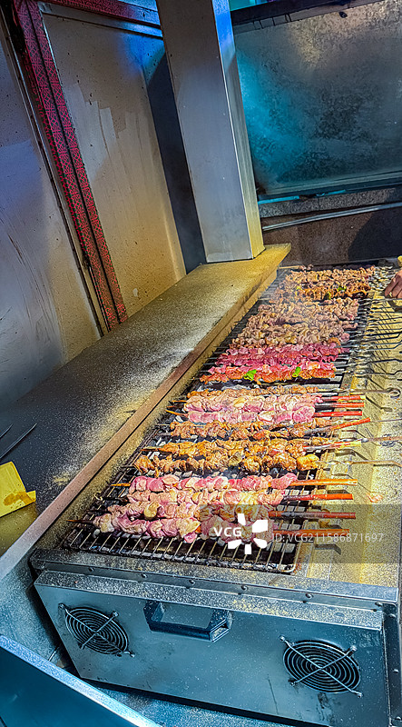 中国饮食产业拍摄主题庙会货摊零售展示，街道货摊烧烤，新疆炉子上的烤羊肉串，户外白昼无人图像摄影图片素材