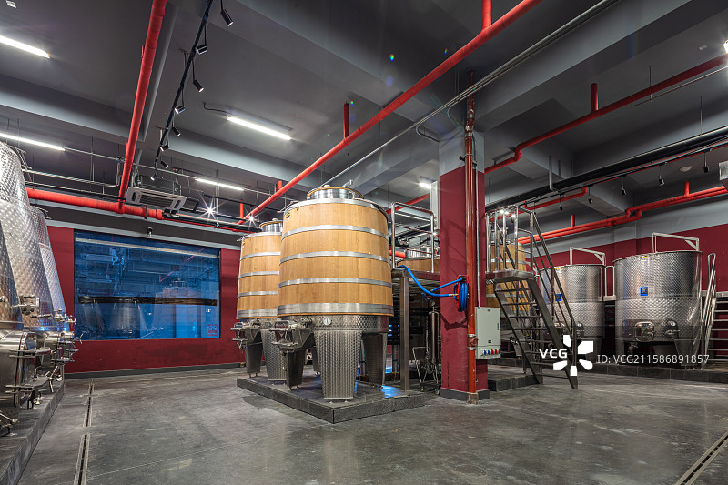 木质发酵桶与不锈钢罐并置的酒庄内部图片素材