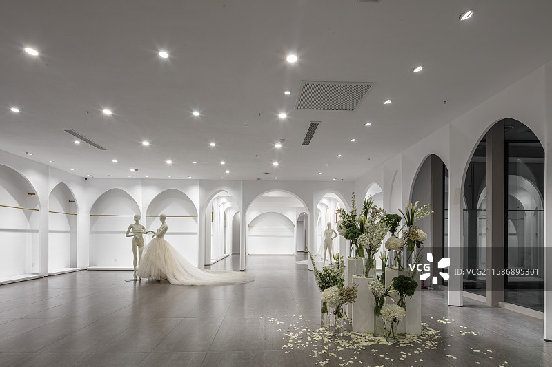 白色拱廊空间中的婚纱与花艺布景图片素材