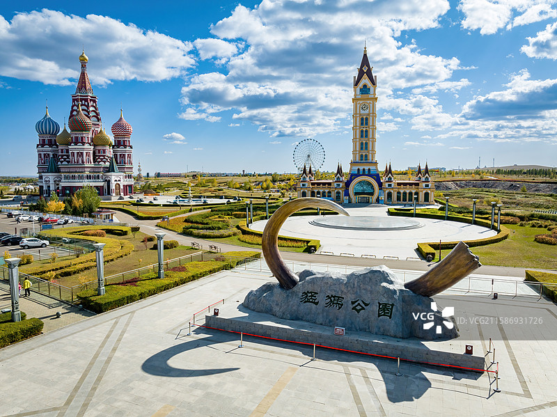 呼伦贝尔扎赉诺尔猛犸公园内，大石头上书猛犸公园，背景俄式建筑高塔，蓝天白云映衬。图片素材