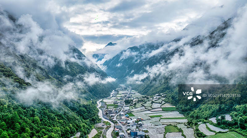 川西理小路理县梭罗沟村的低空云层和村庄图片素材
