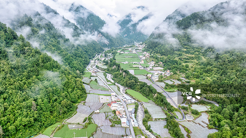 川西理小路理县梭罗沟村的低空云层和村庄图片素材