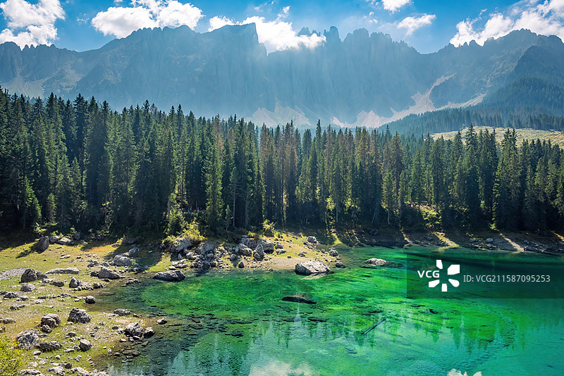 意大利多诺米蒂白云岩清澈的湖泊镶嵌在茂密的森林中，湖水碧绿如玉。周围树木葱茏，形成一片绿色的海洋图片素材