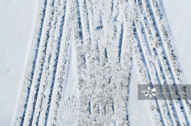道路积雪与轮胎印高角度视图，冬季户外风光，纹理质地，雪地积雪雪景，城市交通出行图片素材