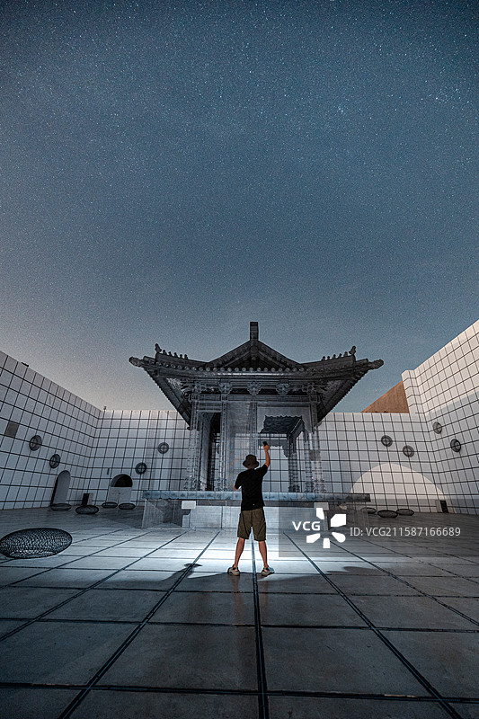 晴朗的有星星的夜晚站在只有河南景区乾台前的人的后视图图片素材