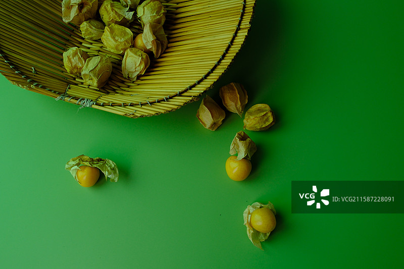 绿色纯色背景下的菇娘水果。留白设计素材背景图图片素材