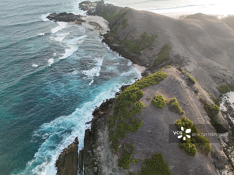 航拍印度尼西亚龙目岛库塔沙滩边的开阔的悬崖海滩上岩石对天空的高角度视图图片素材