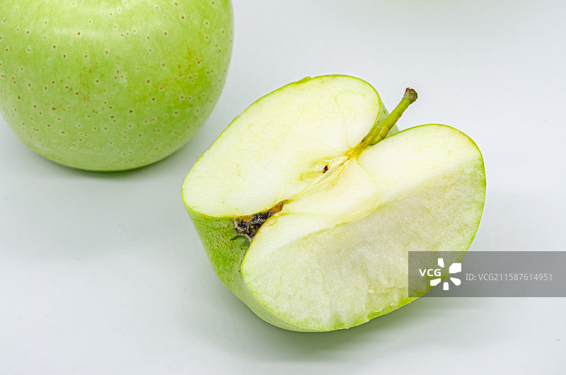 中国传统水果美食饮食产业影棚拍摄主题，一个被人咬过一口的翠绿色黄色的青苹果，室内无人图像摄影图片素材
