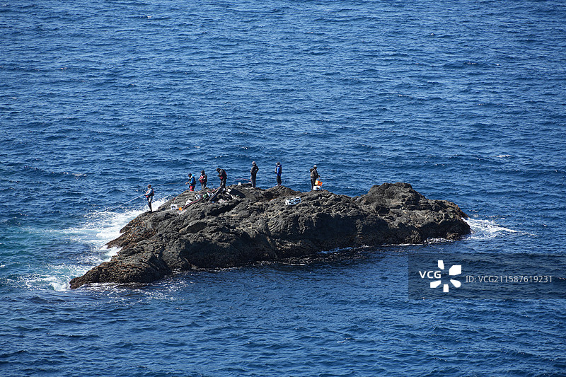 和歌山县串本町潮岬太平洋洋底岩石和钓鱼的人图片素材