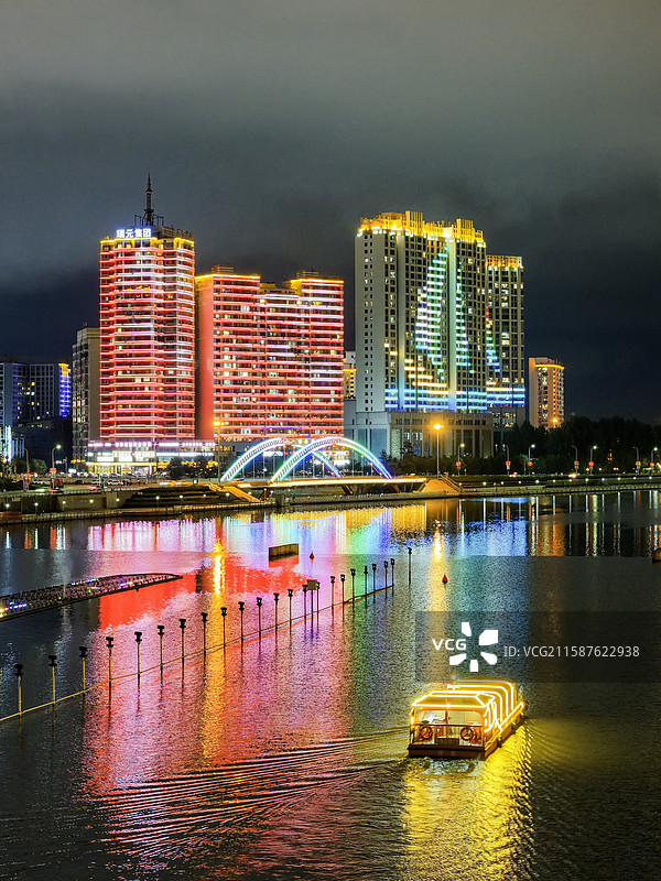 夏季夜晚，无人机航拍吉林省延边朝鲜族自治州延吉市夜景和布尔哈通河游船。图片素材