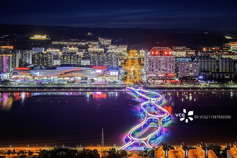 夏季夜晚，华灯初上。无人机航拍吉林省延边朝鲜族自治州延吉市布尔哈通河滨河云廊夜景。图片素材