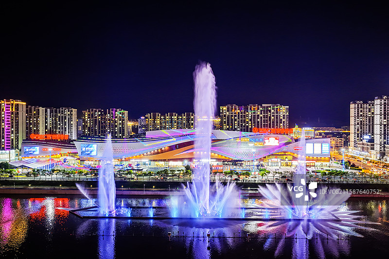 夏季夜晚，华灯初上。无人机航拍吉林省延边朝鲜族自治州延吉市万达广场音乐喷泉。图片素材