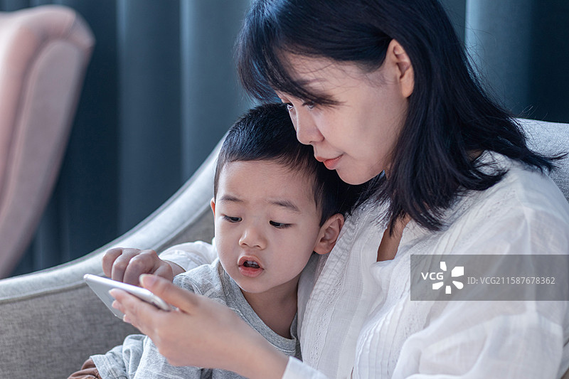 母子一起开心看手机图片素材