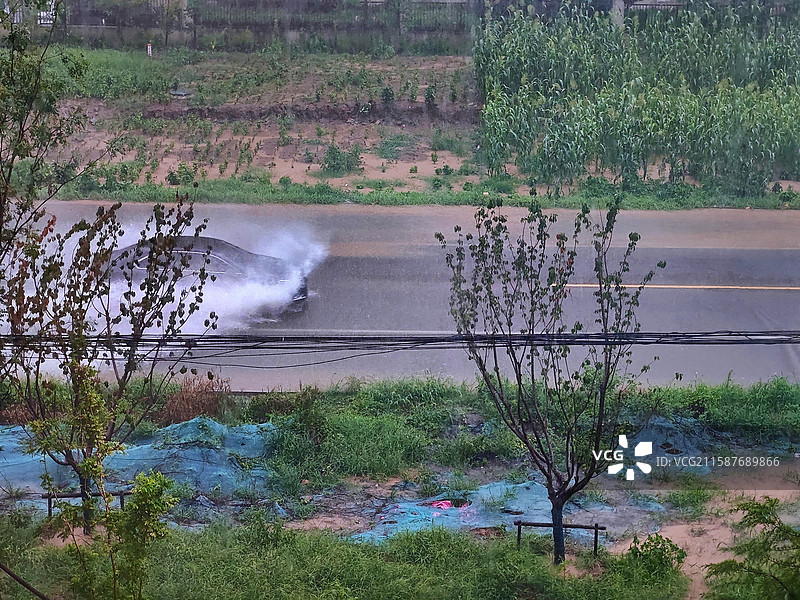大雨，道路上积水汽车通过溅水图片素材