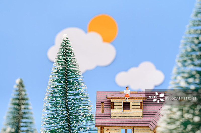 冬天蓝天白云下的圣诞树和房顶的人图片素材