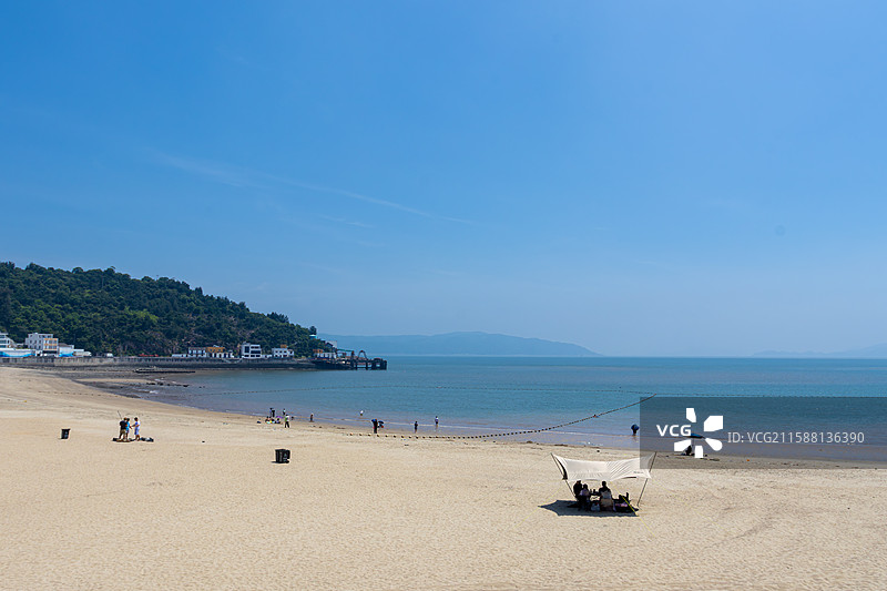 浅黄色沙滩与蓝绿色海面相接的宁静海滩图片素材