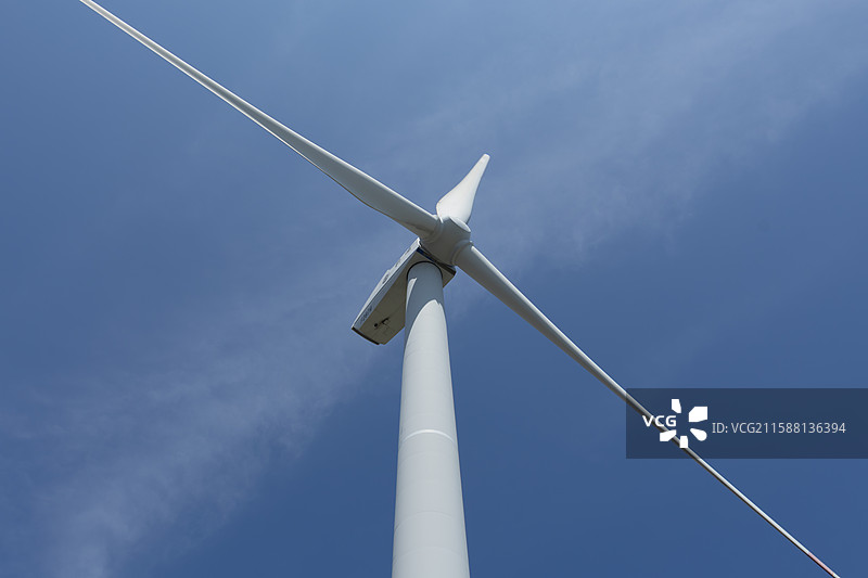 仰视角下的白色风力发电机与蓝天图片素材