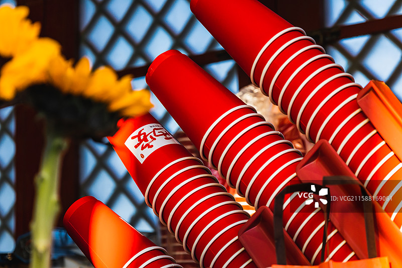 在景点的奶茶店里，红色的杯子叠放在一起，恰巧一个杯子带有城市的logo图片素材