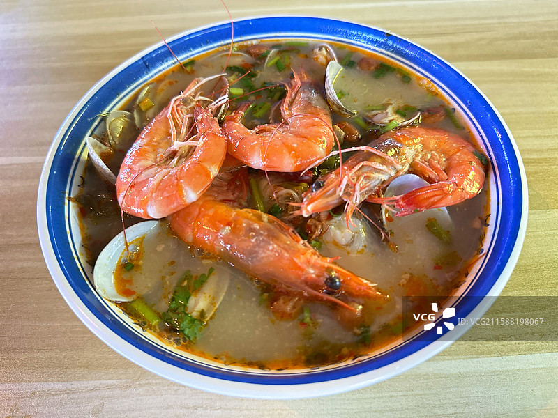 木质桌上碗里的海南特色小吃米粉海鲜抱罗粉特写镜头背景美食节地摊经济商业夜市街图片素材