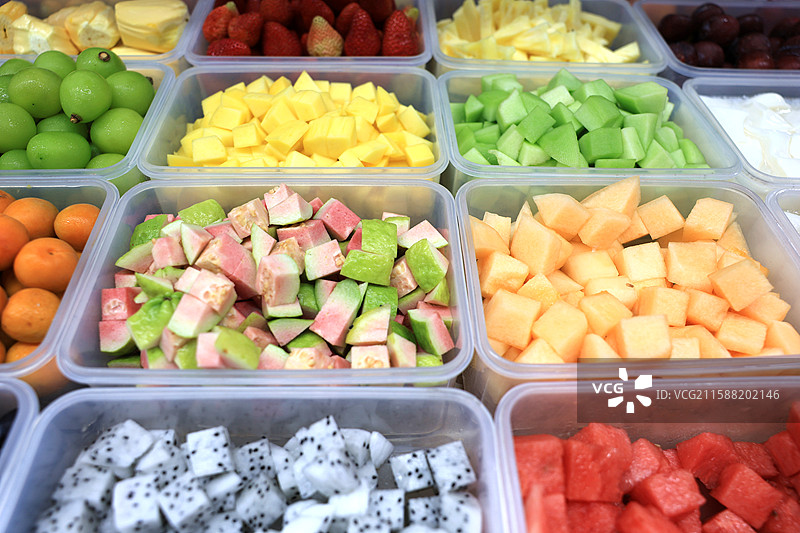 市场摊位摆放整齐的一盒盒各式各样的新鲜水果图片素材