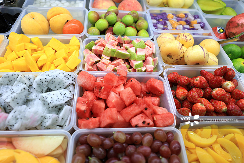 市场摊位摆放整齐的一盒盒各式各样的新鲜水果图片素材