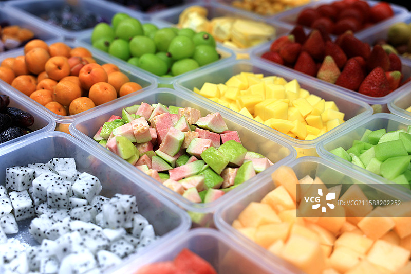 市场摊位摆放整齐的一盒盒各式各样的新鲜水果图片素材