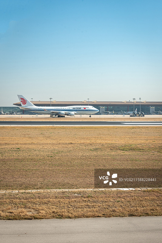 中国国际航空飞机停于首都机场跑道，晴空与航站楼为背景。图片素材