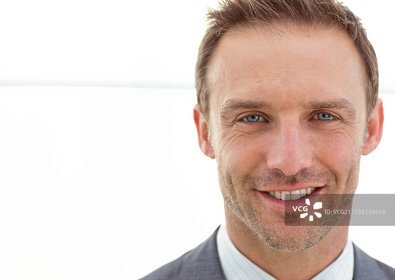 中年男性穿着灰色西装外套，条纹衬衫，在摄影棚中看向镜头，留有空白空间图片素材