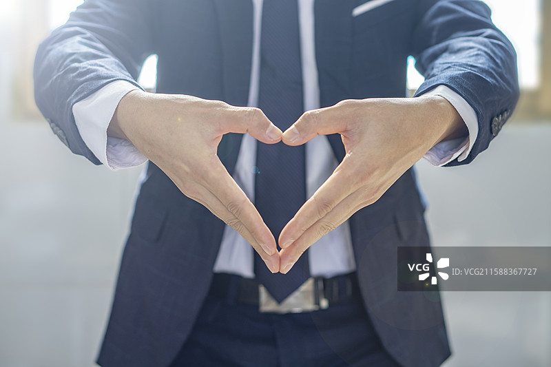 商务人士比划爱心的动作场景图片素材